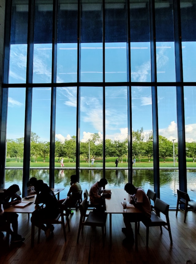 Individuals seated at tables/desks in a library in Luangzhu Village Cultural Art Center.